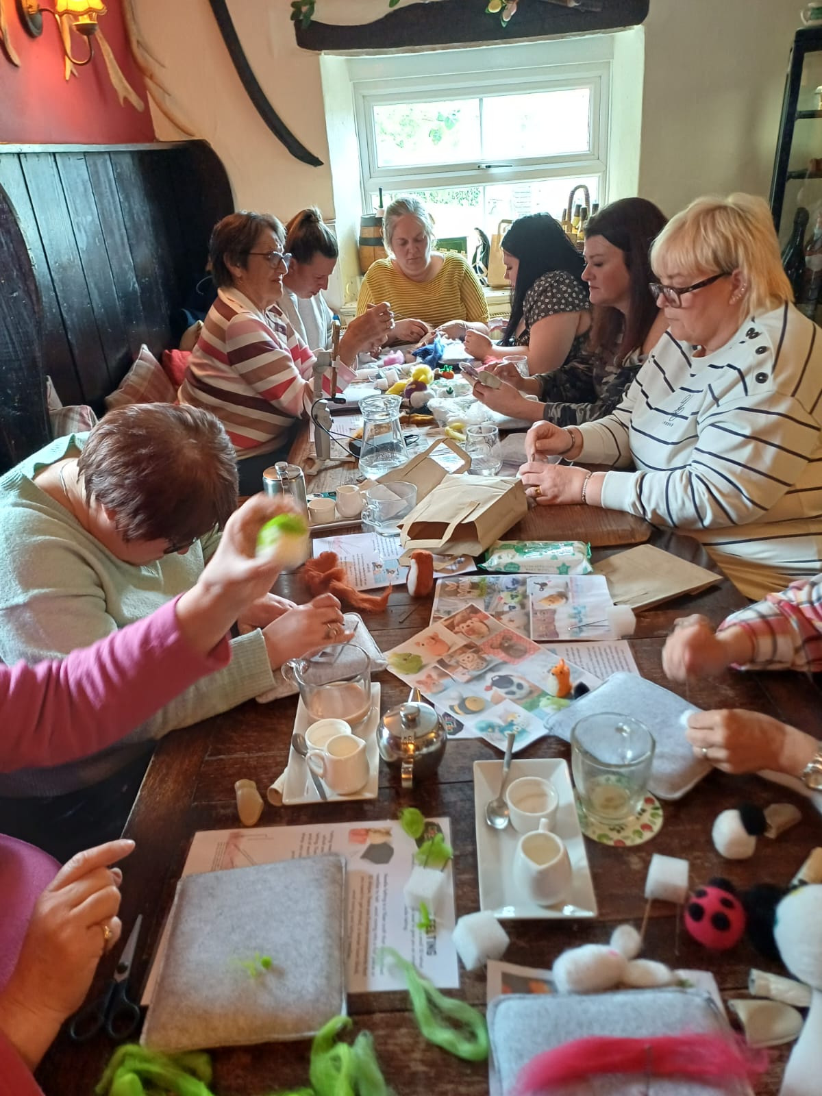 Needle-felting workshop in full swing around a long pub table