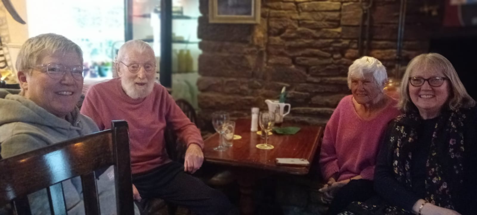 Four regulars enjoying drinks together at a table in The Halfway