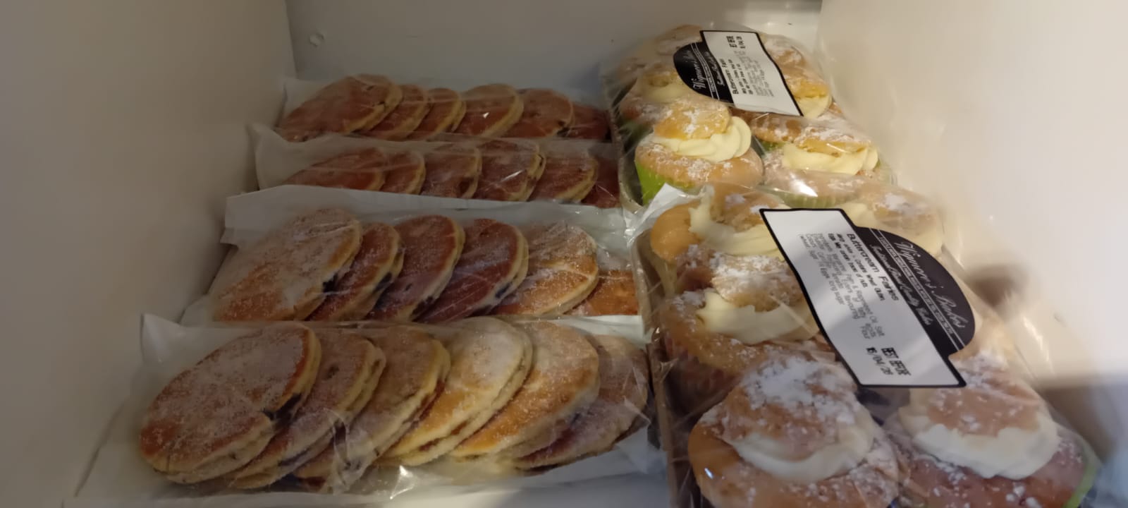 Fresh Welsh cakes and buttercream fairy cakes on the bakery shelf